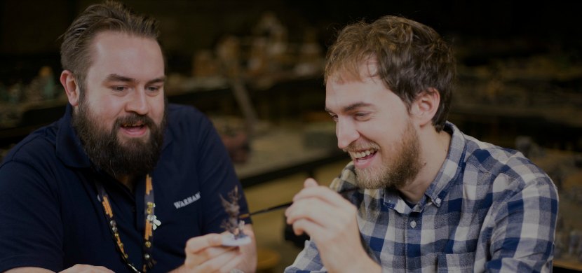 Games Workshop employee with a customer painting miniatures